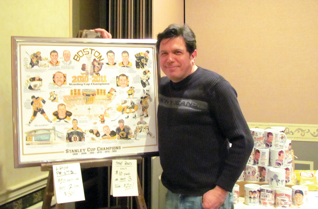 PICTURE PERFECT: Sports cartoonist Frank Galasso stands aside his drawing of the Boston Bruins’ after winning the 2011 Stanley Cup championship. He was one of five Cranston residents who had displays at the 36th annual Cranston Sports Collectors Show.