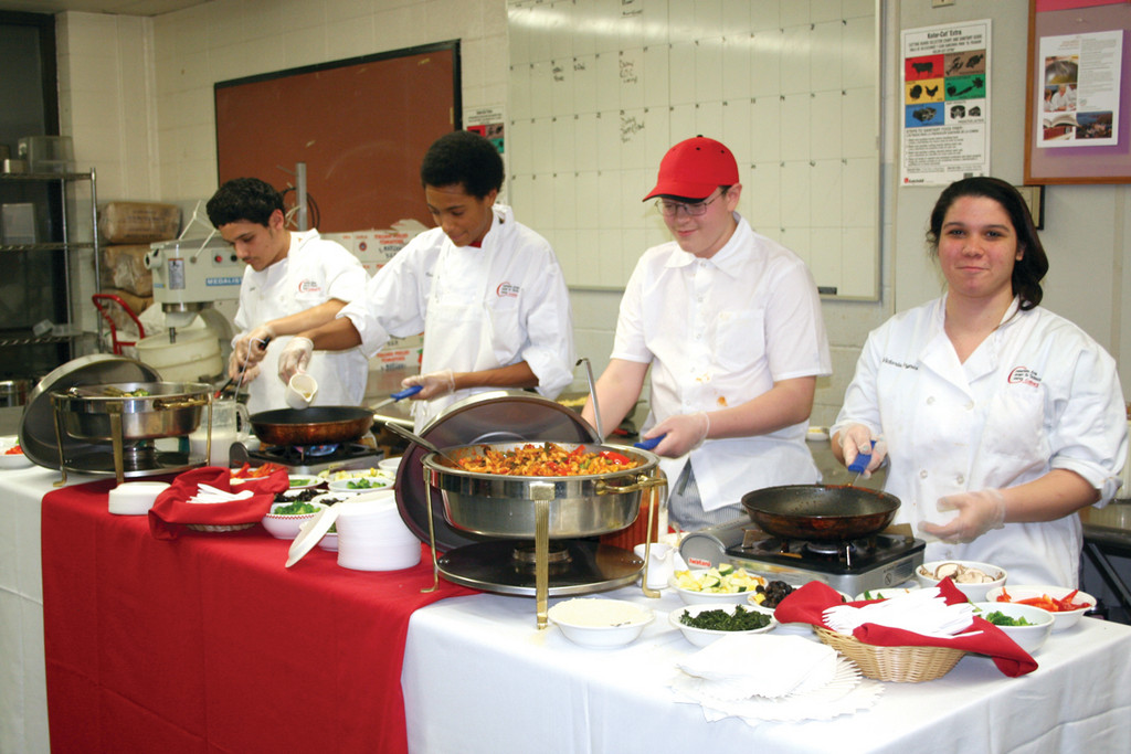 HANDS ON EXPERIENCE: Victoria Brynes, Michael Prata, Terrell Paci and Hector Zenteno serve a gourmet buffet, prepared by the culinary program, to visitors at the open house. Zenteno noted that he transferred out of a private high school in Pawtucket and into CACTC specifically for the career education opportunities offered there.