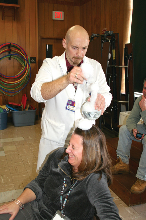 THE RULE OF SCIENCE: When Breindel started his presentation, he told the students that his number one rule was to have fun when teaching and learning about science. Here, he puts his rule into action, as Kerry Pomfret, first grade teacher, laughs when he put bubbles on her head during the performance.