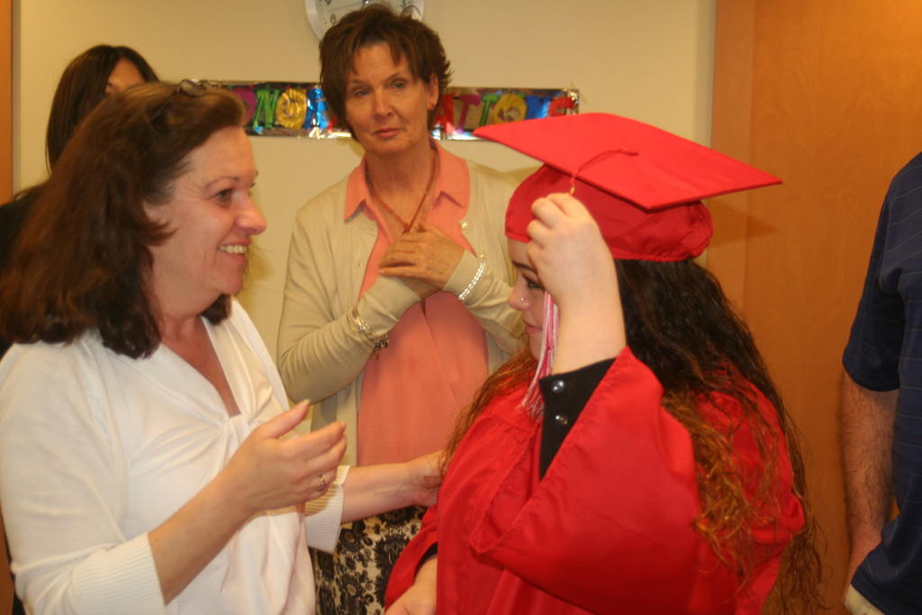 GETTING READY FOR HER BIG MOMENT: Cranston West’s Liz Romeiro helps Tiffany with the final details of her graduation attire while West’s Holly Meyer looks on.