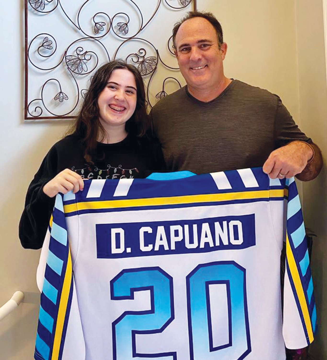 HEADED TO THE HALL: Dave Capuano and his daughter Jaclyn show off the jersey given to members of the RI Hockey Hall of Fame. Capuano will be inducted later this month as a member of the 2020 class.