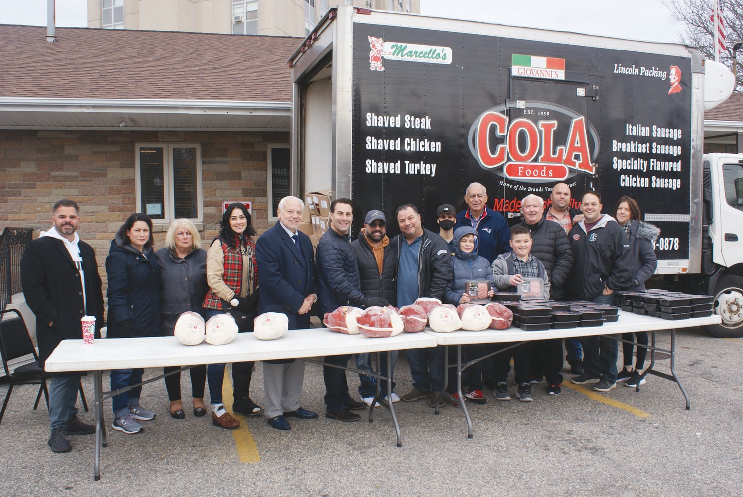 IT TAKES A VILLAGE: Standing in front of the Cola Foods truck were the many volunteers involved in the Free Turkey Giveaway. Cola Foods donated the sausage meat.