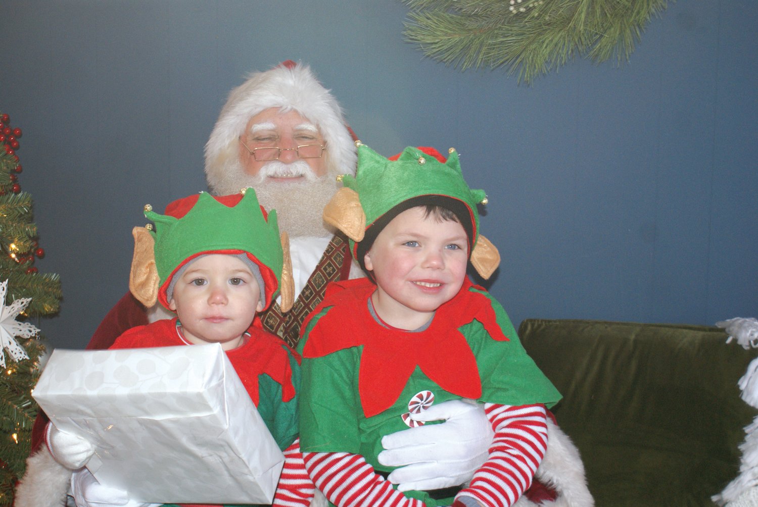 ELVES WITH SANTA: Santa Claus was excited to greet Elf Isaac an Elf Anthony during his Grand Entrance into Garden City Center. His elves help Santa to greet the children. Santa Claus was so happy to return for the event since it was not held last year.