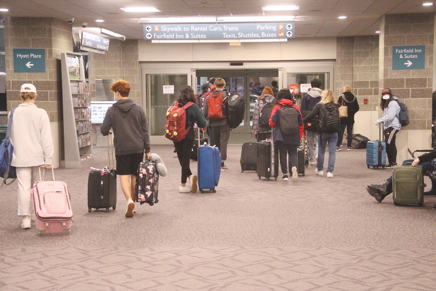 BACK HOME: Travelers arriving on flights Sunday head for the terminal exit after retrieving their baggage.