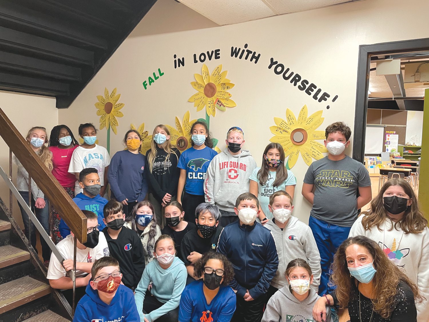 POSITIVELY INSPIRING: Theresa Vessella and her fifth graders show off the positivity wall they worked so hard to create.