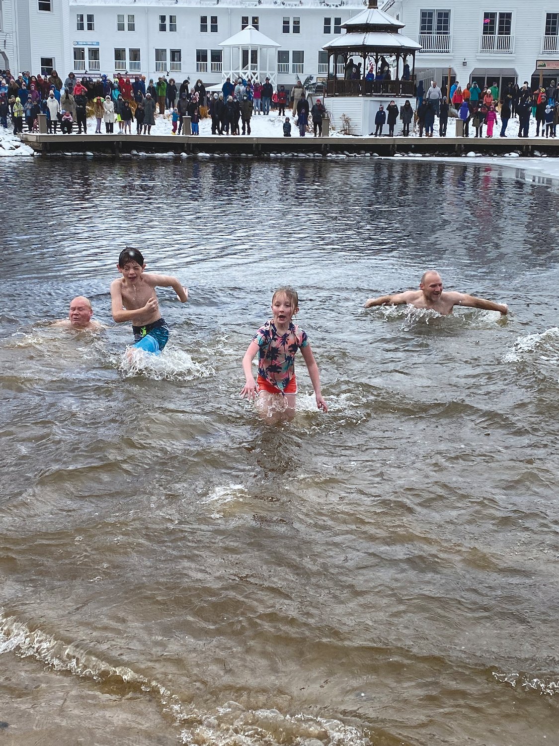 TAKING THE PLUNGE: Grandpa Jerry Shannon, Cousin Tiernan Shannon, Hannah McNally and Uncle Tim Shannon crawl out of the frigid water at the annual "Freezin' for a Reason" plunge in Waterville Valley over Thanksgiving weekend.