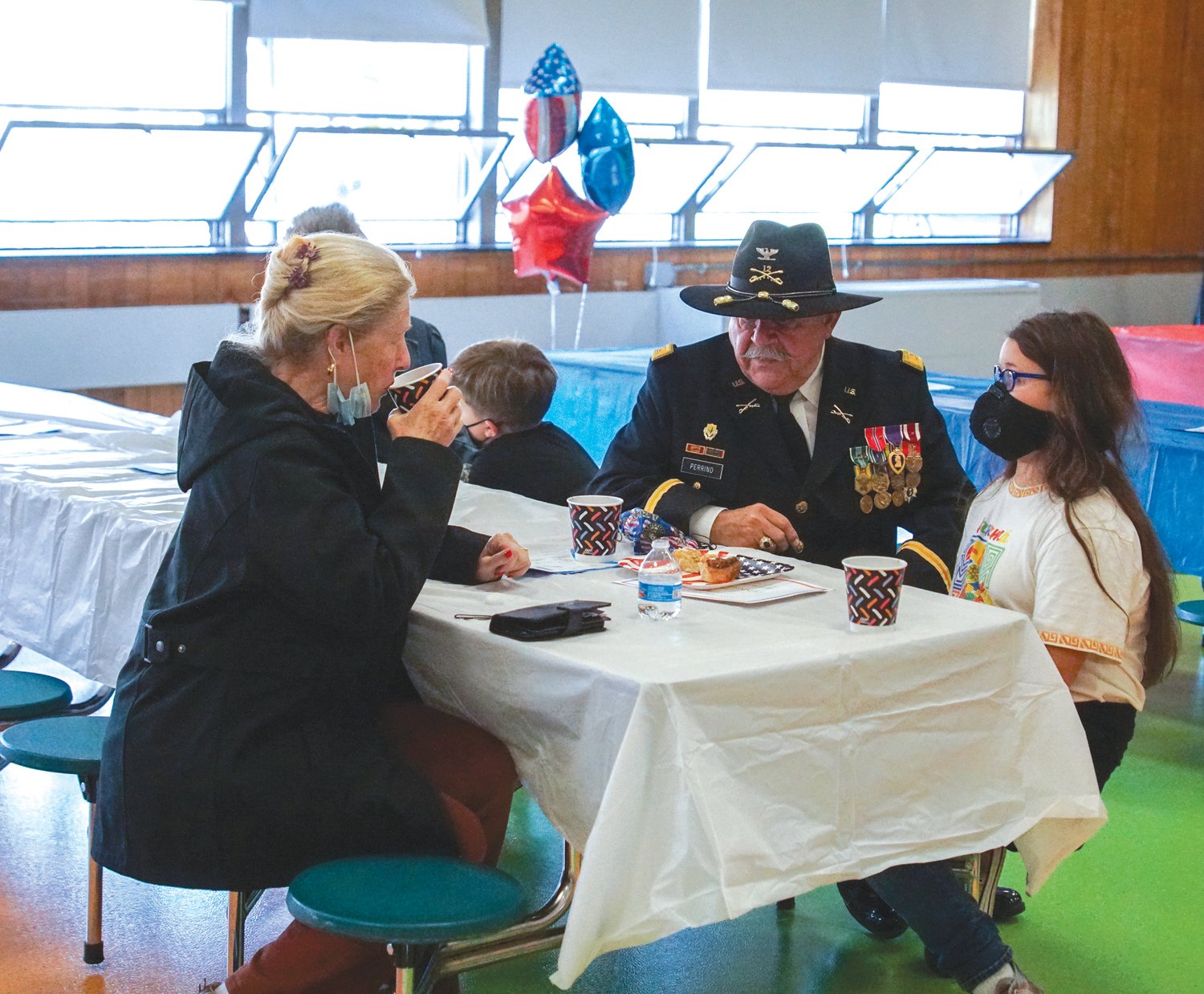 SHARING: Retired Army Colonel Dennis Perrino shares a
drink and snack with his granddaughter, Glen Hills 4th grader
Ramona Perrino, on November 10 during the school's Veteran's
Day Celebration.
