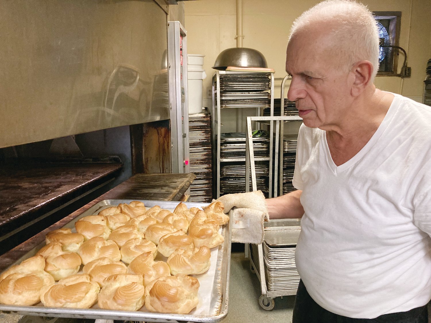 PEAK INTO THE OVEN: DePetrillo checks on zeppoles that were in the oven. He puts them back in since they’re not quite ready.