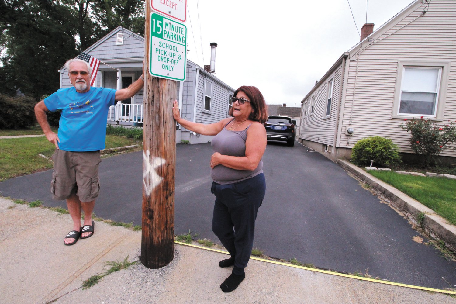 NO MARGIN FOR ERROR: Steve Dionne and Donna Miccolis share a driveway and a utility pole that they agree they would love to get moved, but the city isn’t inclined to help even though the pole is embedded in the city sidewalk. (Herald photo)