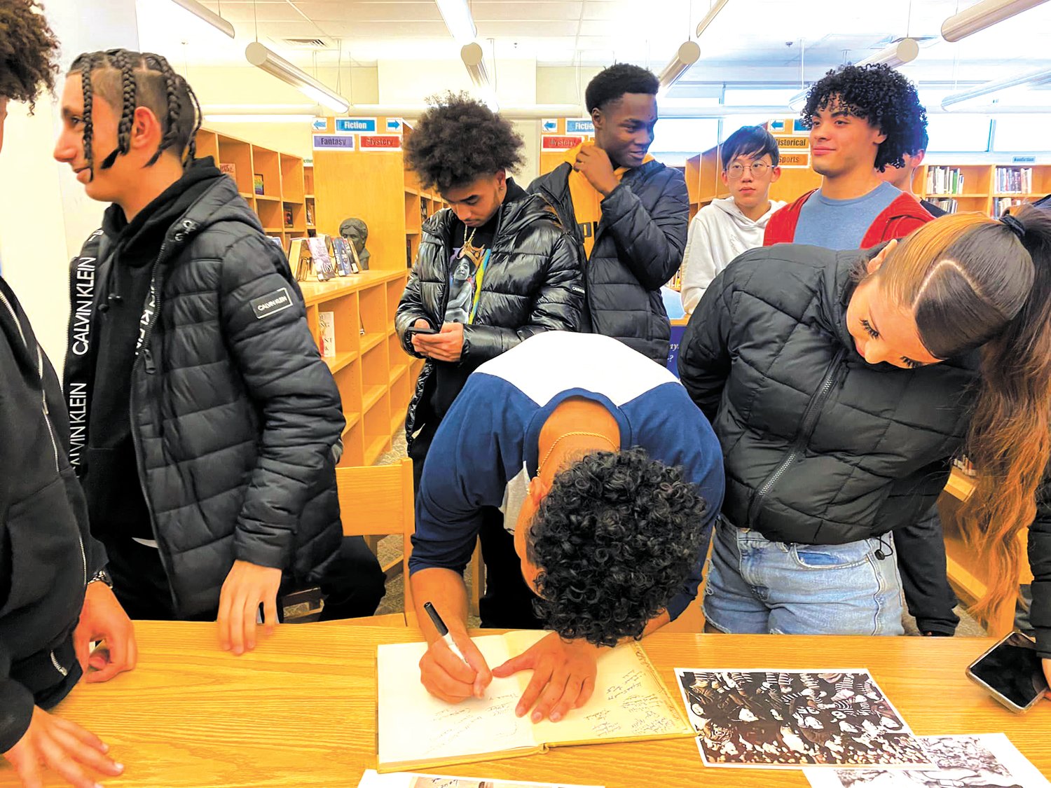 HEY, SAL HAVE A ROCKING SUMMER: Student members of the Class of 2023 happily signed Sal's yearbook at his diploma ceremony on Dec. 20, 2022. (Photo courtesy of Rachel Marchetti)