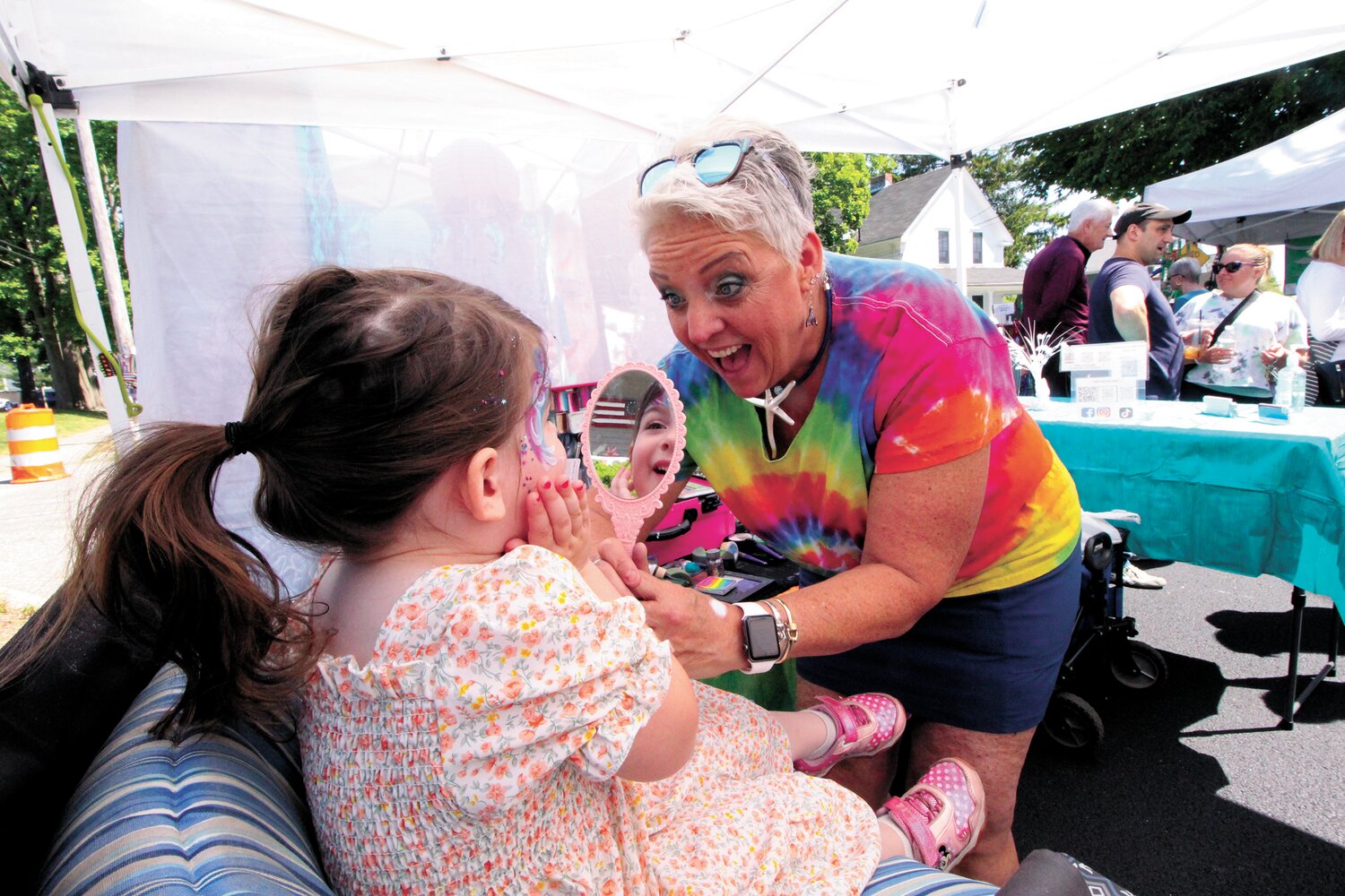 ALWAYS POPULAR: Toni Andersen of Warwick  barely paused from the moment the Gaspee Days Arts and Crafts officially opened Saturday morning. Her face paintings delighted kids of all ages including Violet who is pictured here. As typically the case, parents ask how they wash faces clean and kids protest when they learn they won’t last .