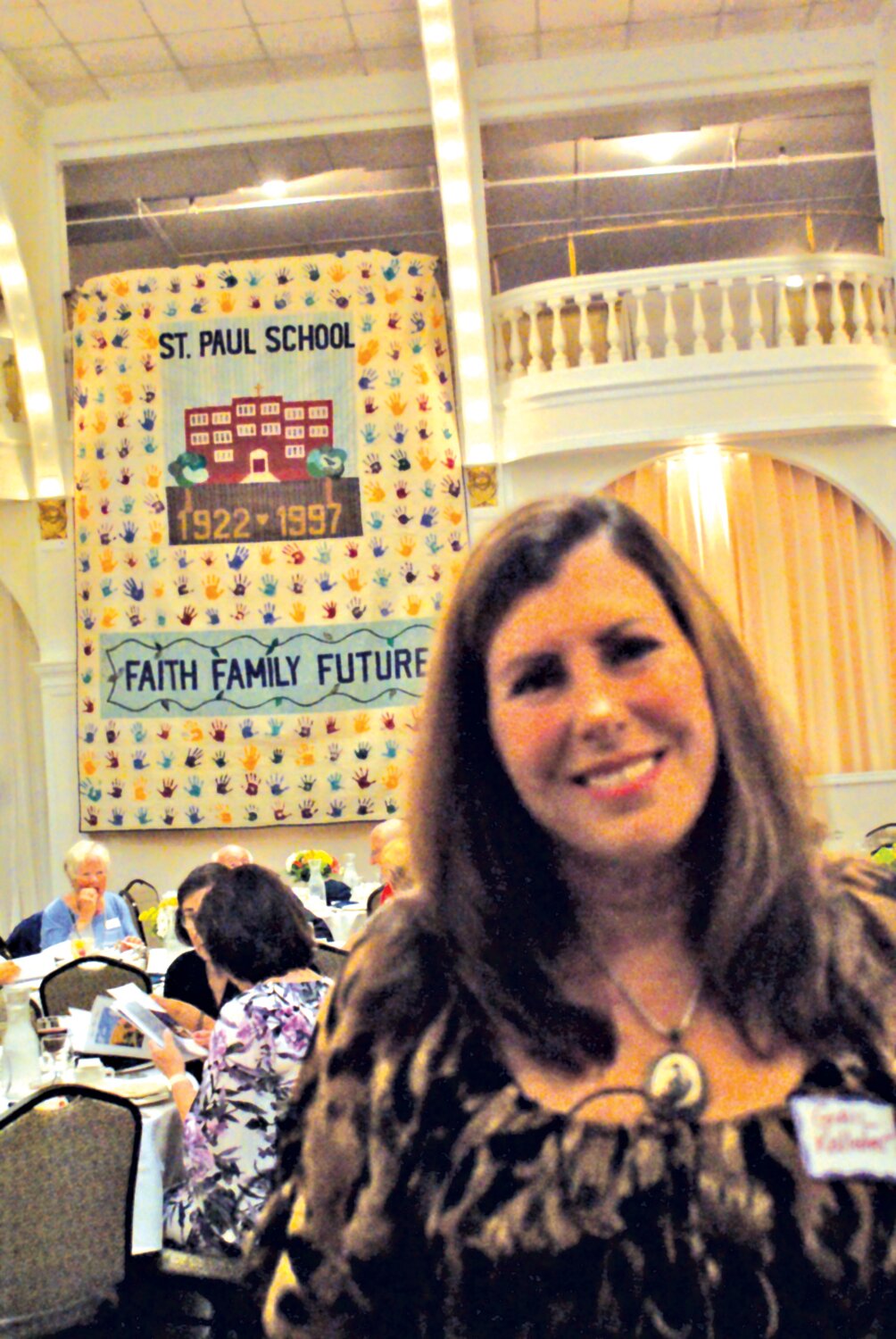 HARD WORK OBSERVED: Gail Kelleher smiles as her handmade quilt decorates the gala with a piece of history.