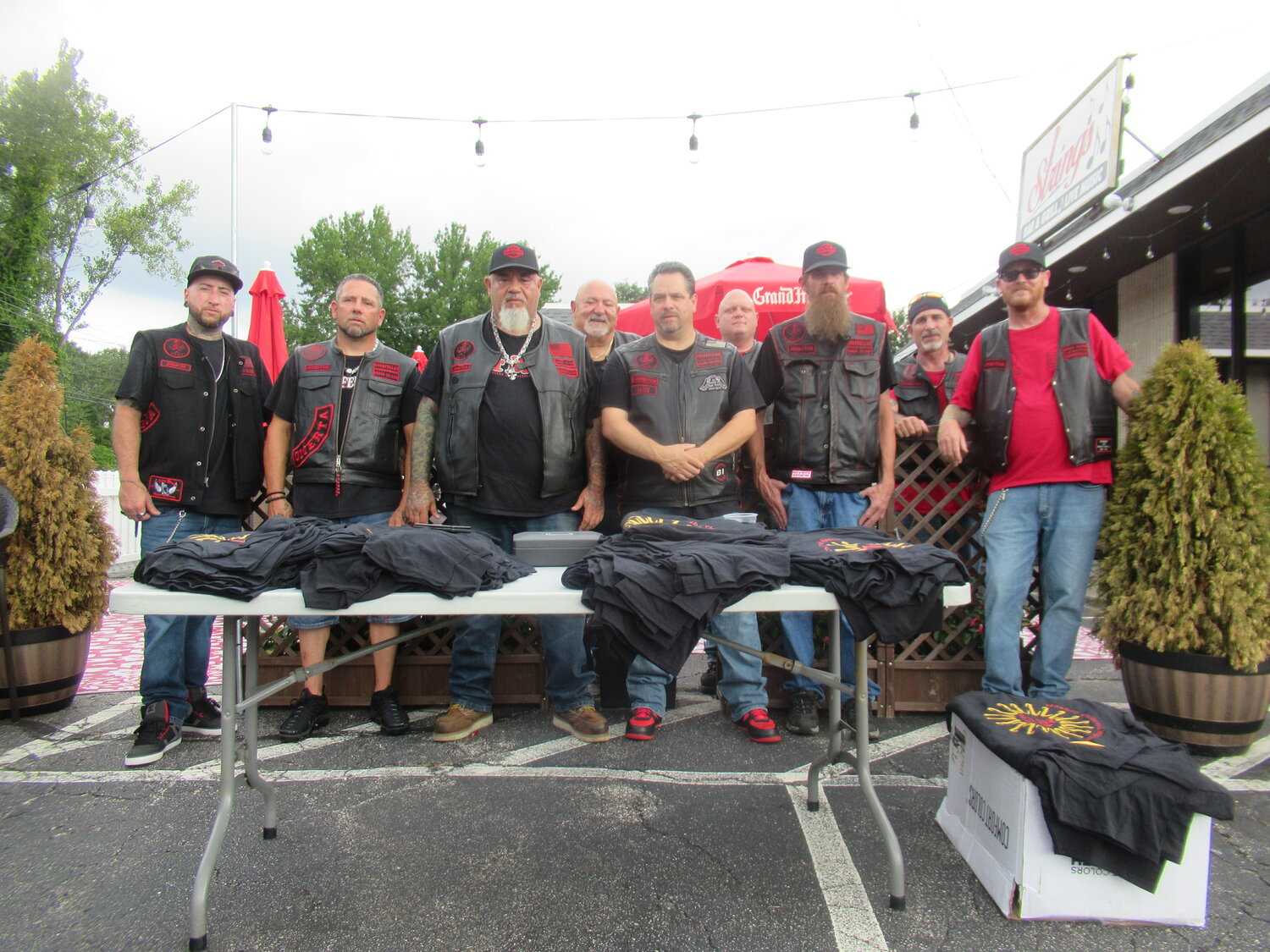PROUD PRESENTERS: Members of the Goodfellas Motorcycle Club are standing behind a table topped with special tee shirts for the bikers in their 7th annual run. The group includes Ryan Connolly, Joe Ratte Jr., Derek Duffy, Cal Calabro, Nick Demetropoulos, Bill Pryor, Kevin Marandola, Ray Chase, Kevin Hart and Ryan Koscielnak.